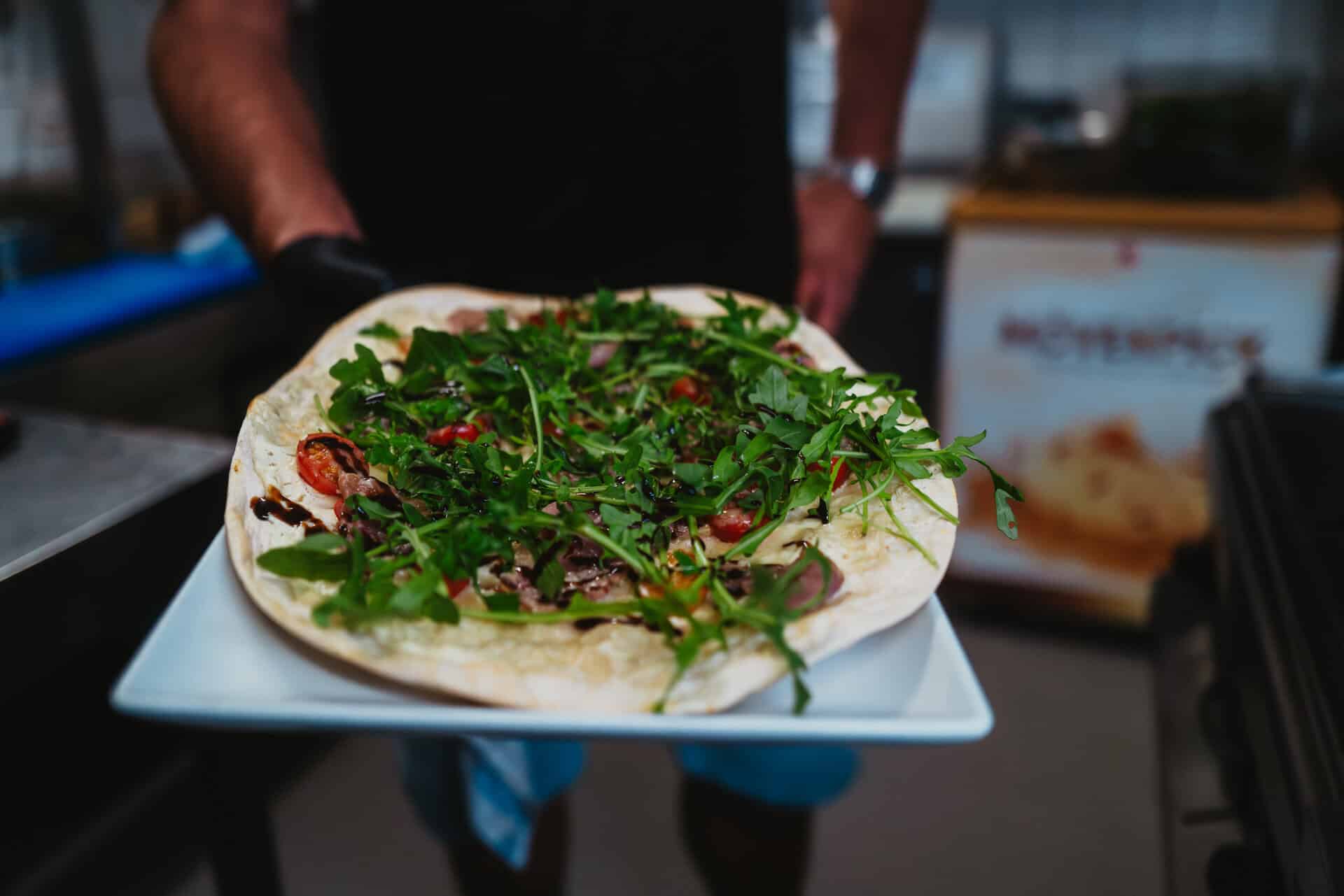 Frische Pizza mit Kräutern und Tomaten bei Bungalow 7.