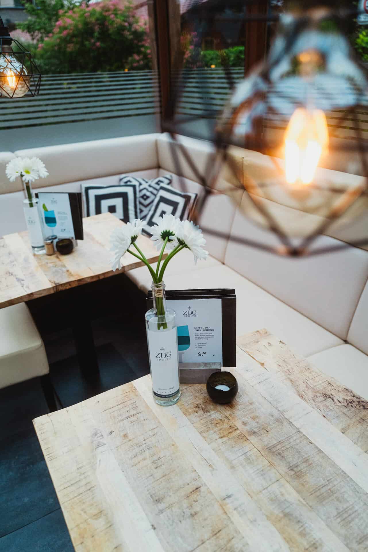Cozy restaurant lounge with modern decor, flowers, and ambient lighting at Bungalow 7.
