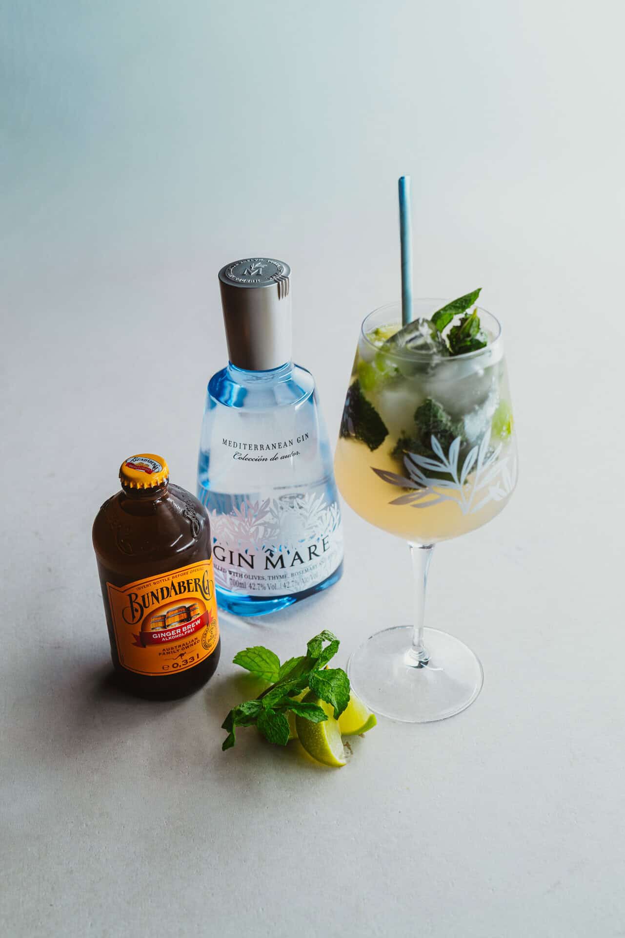 Refreshing cocktail with gin, mint, lime, and ice in a glass.