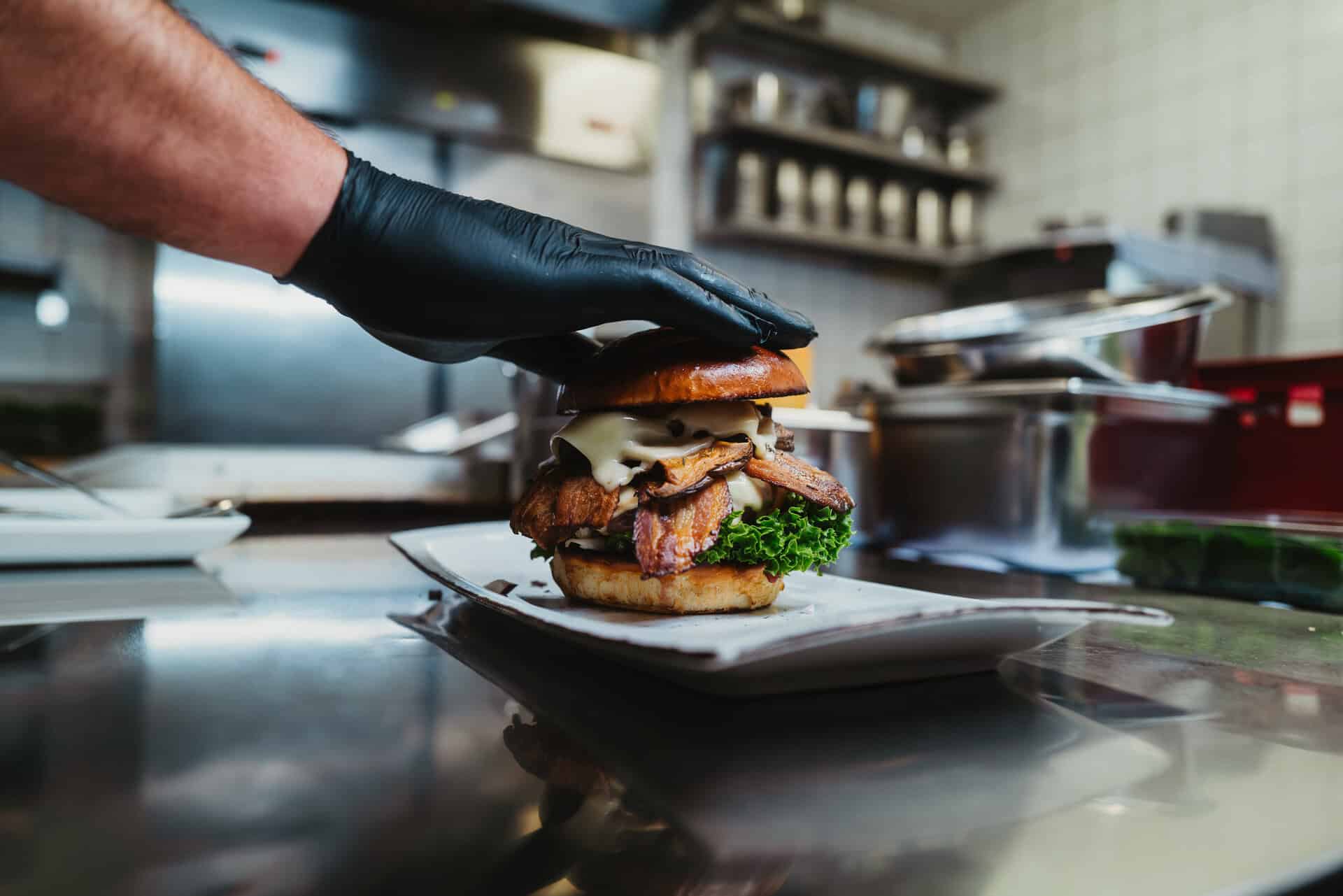 Koch handfertigt Gourmet-Burger im Bungalow 7 Restaurant.