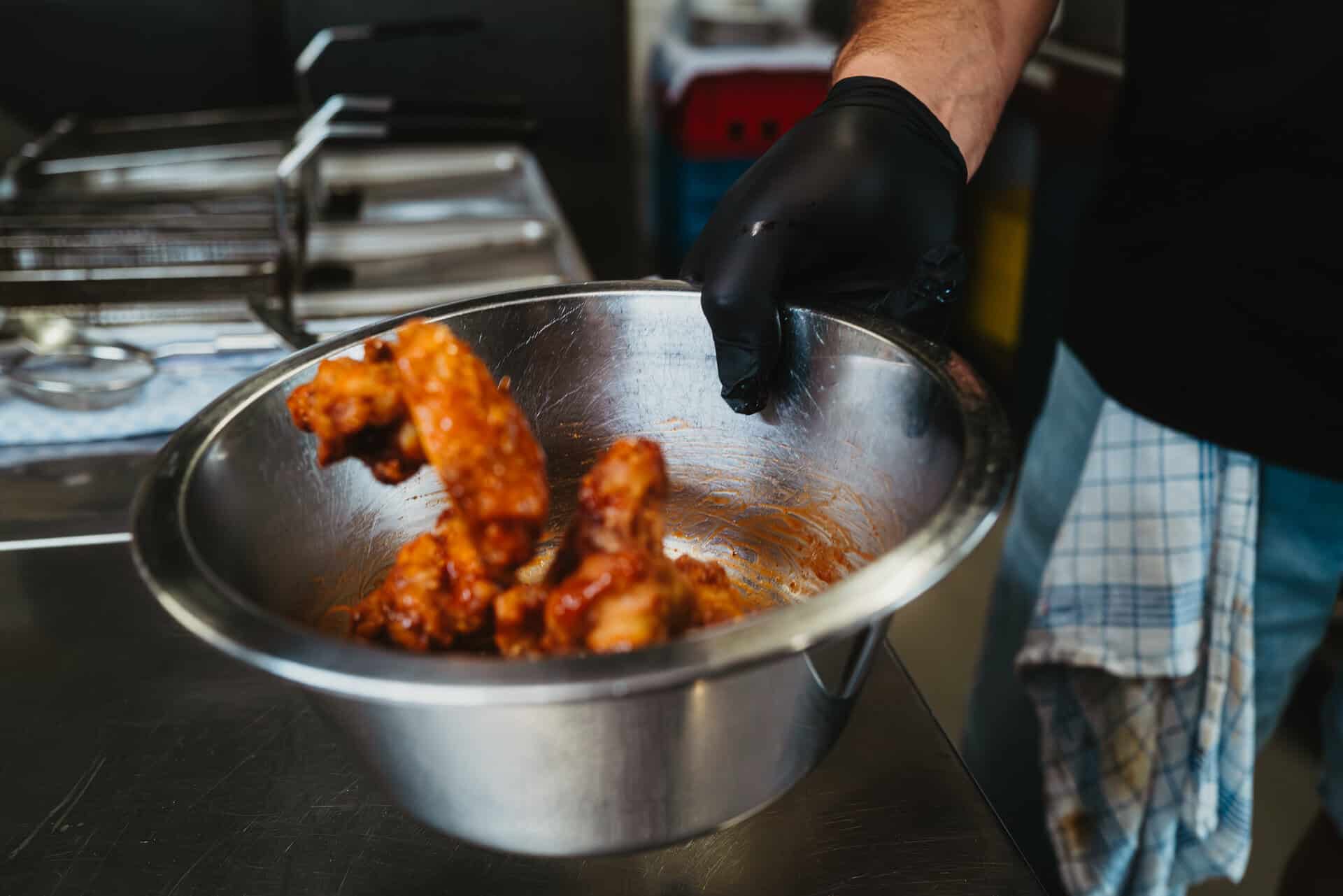 Freshly fried chicken wings in a metal bowl
