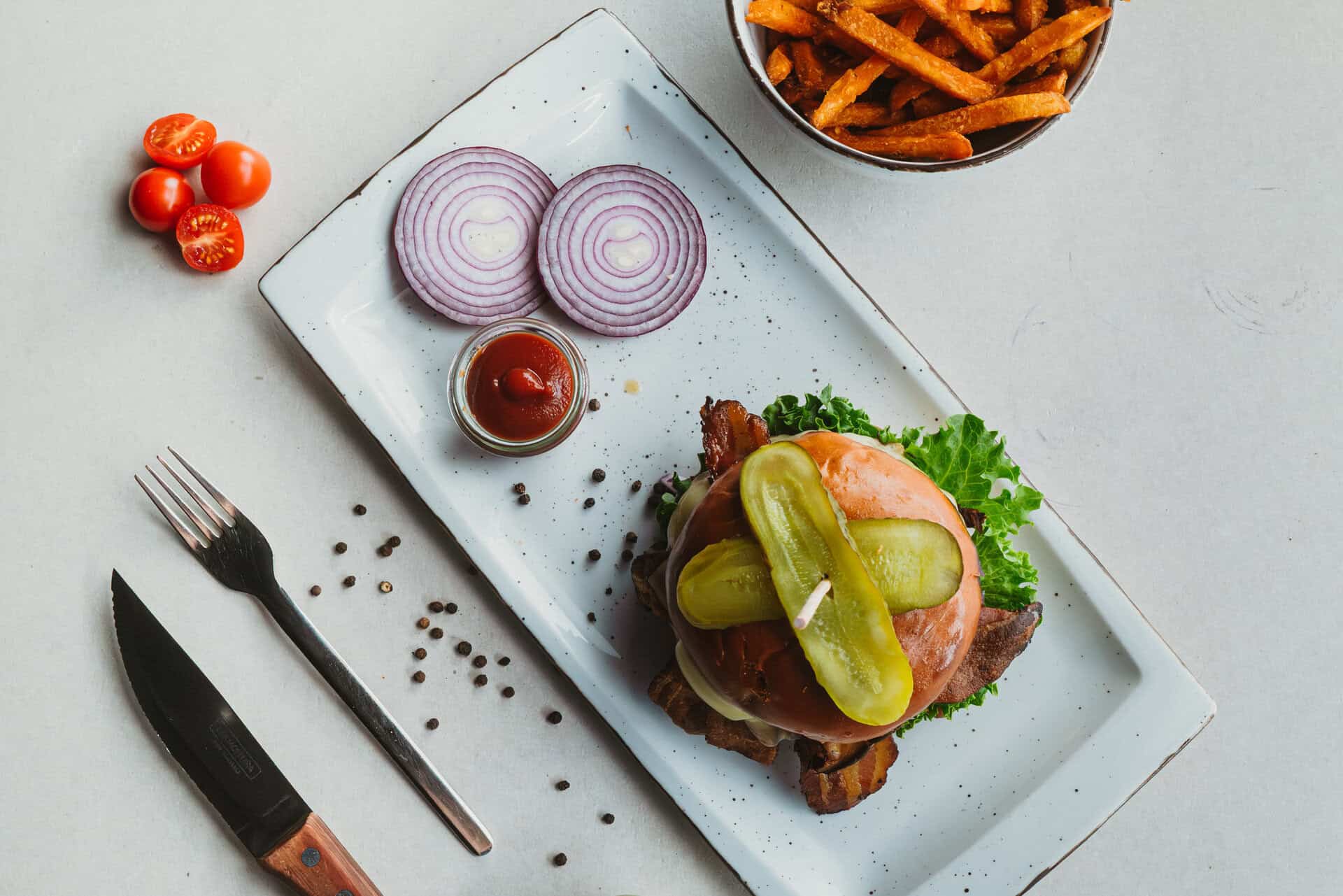 Leckerer Burger mit frischen Zutaten und Beilagen im Bungalow 7.