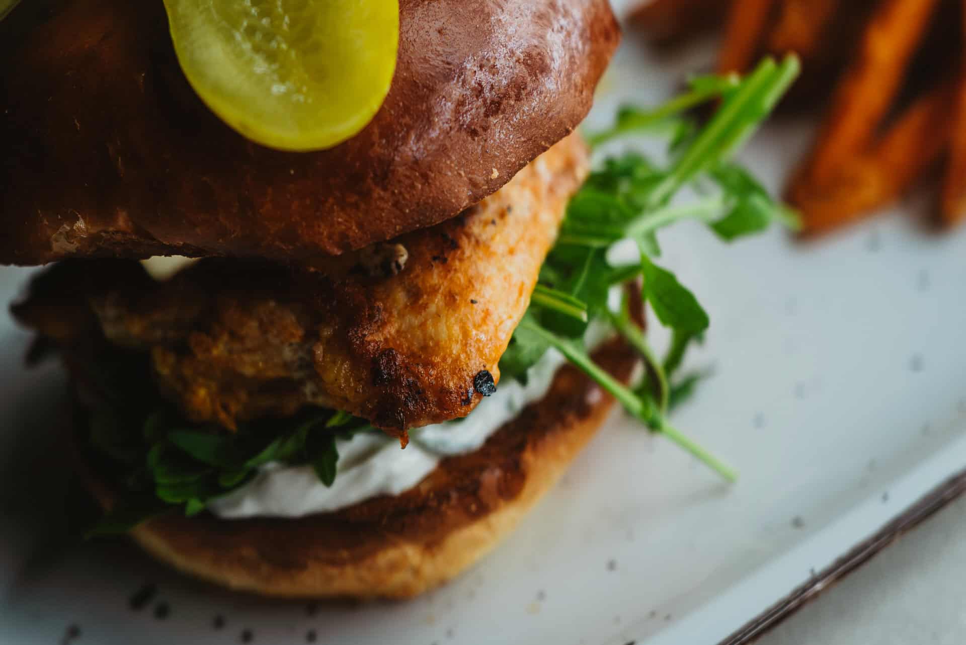 Saftiger Burger mit Speck, Salat und Gurke.