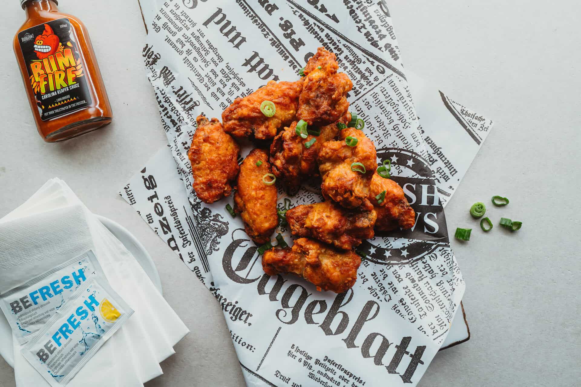 Knusprige Chicken Wings mit grünen Zwiebeln und Soße.