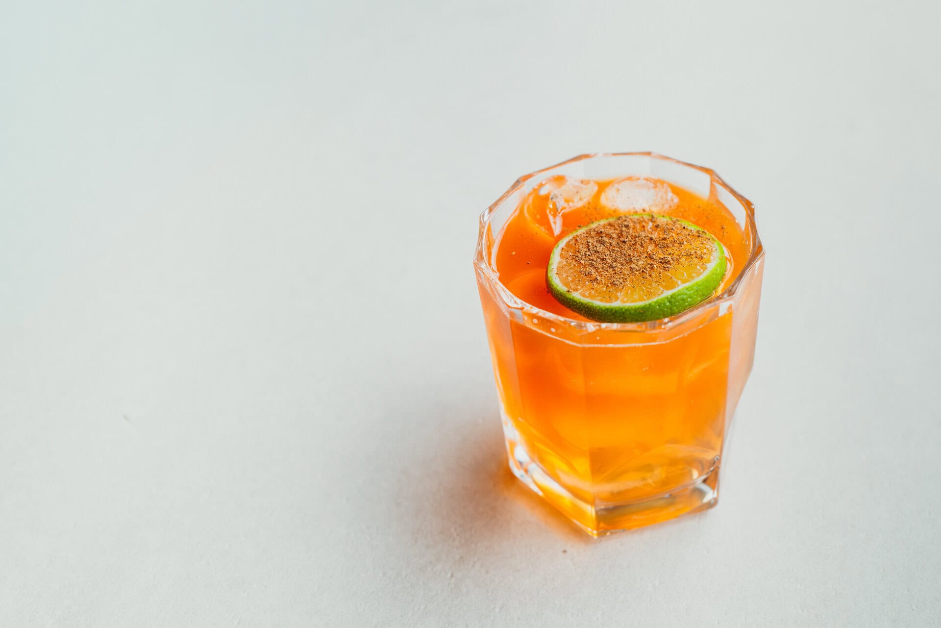 Bungalow 7 Cocktail mit Limette und Orangenscheibe.